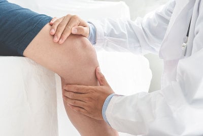 理疗师对病人的腿进行康复治疗。运动理疗概念，全景横幅