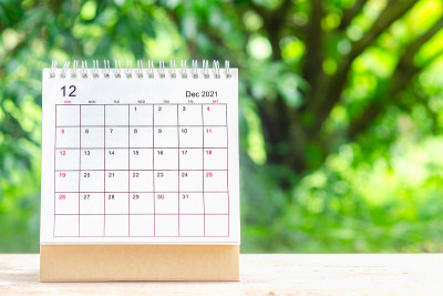 12月，在绿色自然背景的木桌上，为组织者规划和提醒2021日历桌。