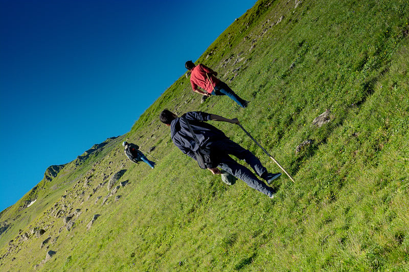 背着背包和拄着拐杖在阿尔特文高地行走的徒步旅行者