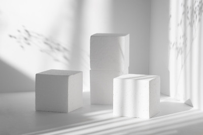 3d讲台，用于包装，化妆品演示。三个不同高度的白色方形场景，映衬着干净的墙壁和鲜花的阴影。美的概念
