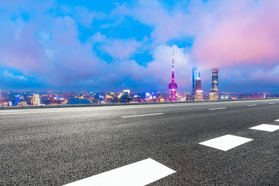 晚上，上海的天际线和现代建筑与空的公路，中国。