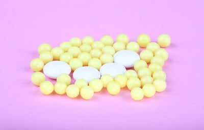 粉红色背景上的黄色维生素