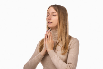 迷人的金发女孩祈祷家人健康，双手合十祈祷