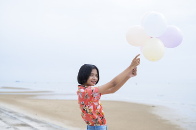 亚洲年轻女孩喜欢在海滩上玩气球。