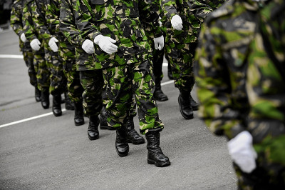 身穿绿色迷彩服的士兵行进