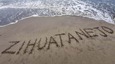 沙滩上的沙子与字ZIHUATANEJO和水从海浪的大海