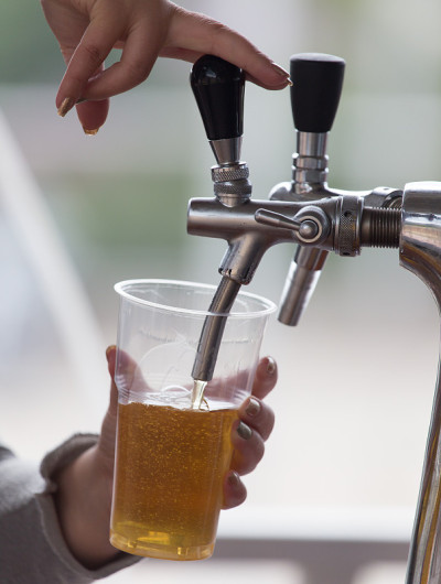 酒保把啤酒倒进塑料玻璃杯