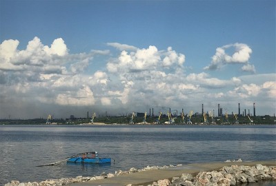 城市景观管道厂和吊车在江边港口，天空晴朗白云