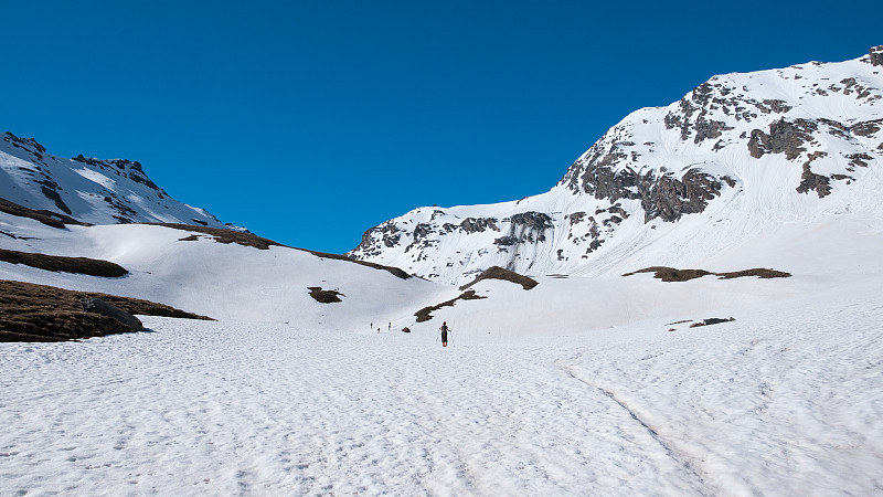 登山运动员在雪坡上滑雪向山顶旅行。战胜逆境，达到目标的理念。