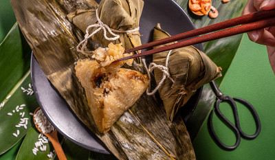 粽子，女人吃着绿色的粽子桌上的背景，食物在端午节的端午概念，拉近，复制空间，俯视图，平铺