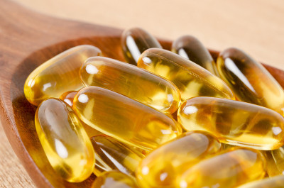 鱼肝油omega - 3凝胶胶囊放在木勺上。