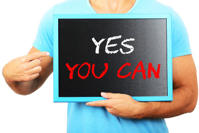 一个人手里拿着黑板，指着“YES YOU CAN”