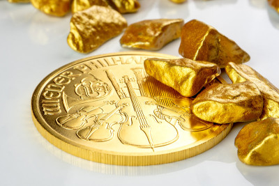 黄金奥地利爱乐一盎司硬币铺在一堆金块上，黄金矿石
