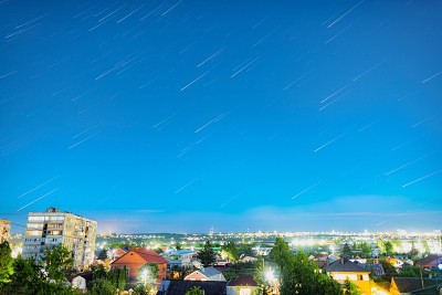 在一个温暖的夏夜，城市上空的星迹看起来像流星