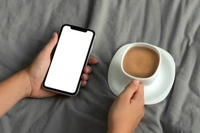 女人的手拿着智能手机与空白复制空间屏幕为你的短信或信息内容的剪切镜头
