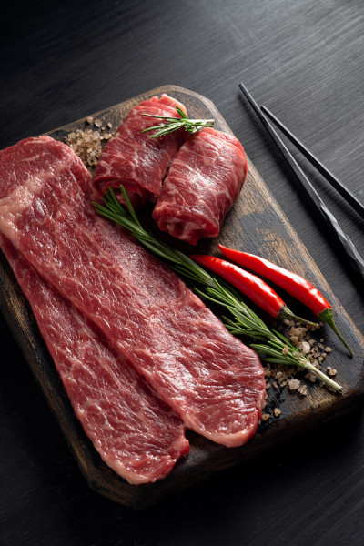 生大理石牛肉块黑色安格斯烤在木板上，在黑暗的背景。为寿喜烧肉