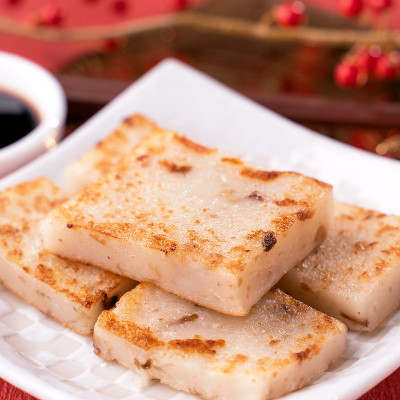 中国农历新年食物概念，美味的萝卜萝卜糕，当地美食在餐厅酱油在红色的背景，近，复制空间