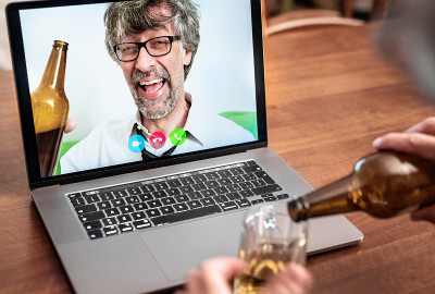 朋友们在视频通话中喝啤酒，生意上的同事通过视频会议为成功干杯，商人们在工作后喝酒并抬起他们的手肘