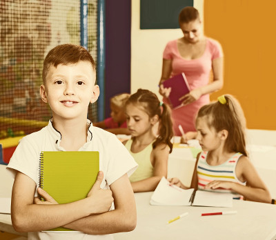 一个男孩在学校课堂上拿着笔记本的肖像