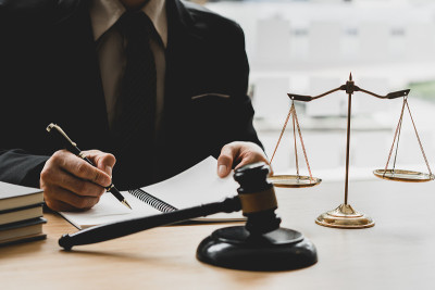 正义与法律观念。法律顾问在办公室向客户提交一份已签好的法律合同或召开法律团队会议