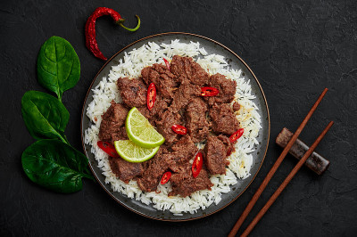 牛肉仁当放在黑色的盘子上，放在黑色的石板桌上。印尼巴东菜荤菜。亚洲食品。俯视图