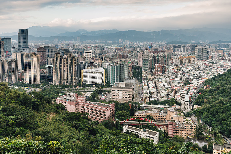 从象山象山的傍晚空中俯瞰台北市区，以山的层次为背景。