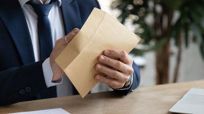 商人的手打开纸袋，取出信件