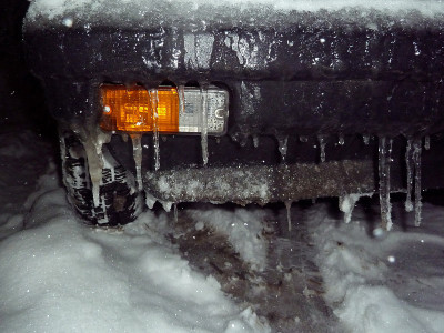 车灯旁的冰柱和轮胎上的雪