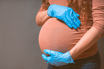 孕妇戴蓝色手套预防流感和病毒。医疗保健的概念。怀孕与感染概念