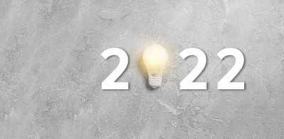 2022年，一个悬挂在灰色混凝土背景上的灯泡。成功的经营理念和创意的创新理念。平铺，俯视图，复制空间