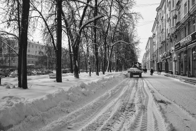 冬天，一辆拖拉机在清扫城市街道上的白雪。黑色和白色