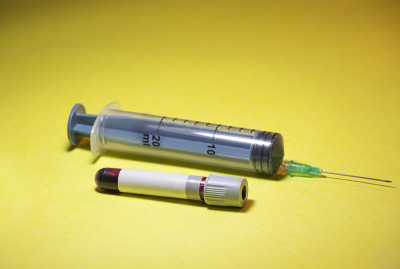 冠状病毒Covid-19疫苗与注射器分离的黄色背景
