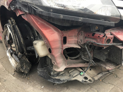 前面的红色汽车在街上被撞毁，受损的汽车在城市的道路上碰撞后。