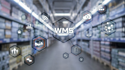 模糊仓库背景上的题词WMS。Werehouse管理系统。