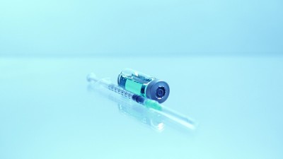 疫苗瓶及无菌针头注射器。新型冠状病毒(COVID - 19)疫苗的医学研究、开发和生产概念。用于制药
