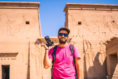 一位年轻的摄影师在菲莱神庙(Temple of Philae)，这是一座从尼罗河上俯瞰的希腊罗马建筑