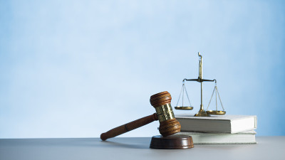 法官用法律书籍和正义的天平敲打。正义观、法理学、法理学。