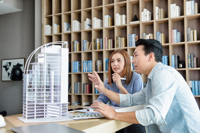 建筑工程师或女建筑师在一起开会。头脑风暴管理的一个想法，以找到一种方法来处理建筑和内部。