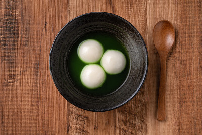 抹茶大汤圆和抹茶汤放在木桌上。