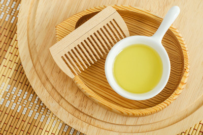 小白碗，里面有化妆(按摩、清洁)油和木质发刷。天然护发、spa美容配方。俯视图，复制空间。