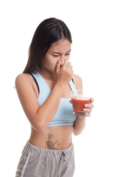 美丽健康的亚洲女孩讨厌番茄汁。