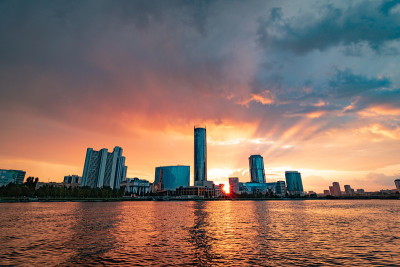 美丽的多云日落在城市池塘。俄罗斯叶卡捷琳堡的城市景观，摩天大楼在水中倒影