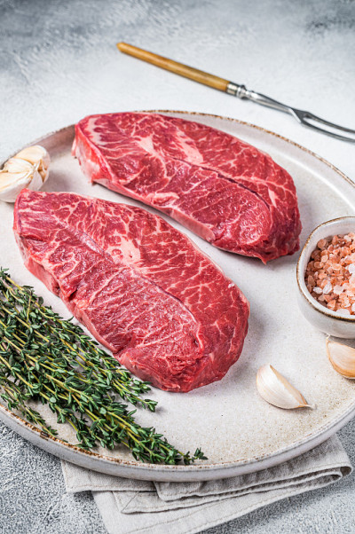 生蚝叶或平铁烤牛肉牛排与药草盘。白色背景。俯视图