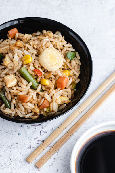 蔬菜炒饭和鸡蛋，用筷子和酱油盛在碗里。中国菜