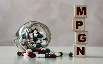 缩写为MPGN(膜增生性肾小球肾炎)的文字是在一个明亮的背景下的木方和一罐药丸