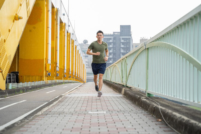 一个年轻人正在城市里跑步。