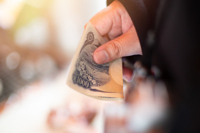 手握日元现金支付购物。