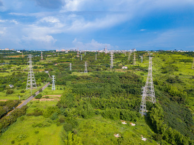 鸟瞰图高速公路和高电压金属柱在工业区。电塔。台湾台中市区森林景观中绿树俯视图。