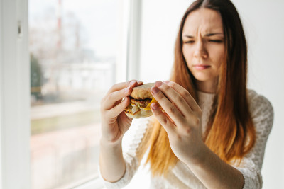 一个年轻女孩表示她不喜欢汉堡。拒绝不健康饮食的概念形象。