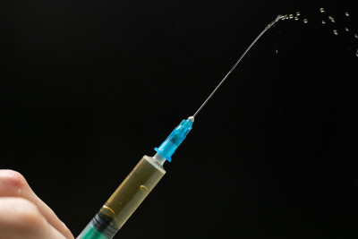 注射器与注射滴在一个黑色的背景与副本的空间